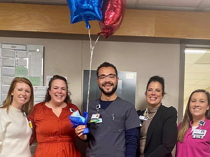 Mayson Lane (holding balloons) smiles with nursing leaders after awarded his RFTS scholarship.