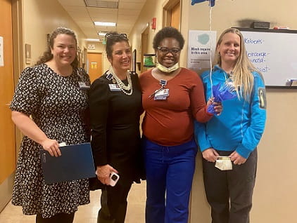 Starr Wilbert (holding balloon strings) stands with 3 nursing leaders to celebrate her RFTS scholarship.