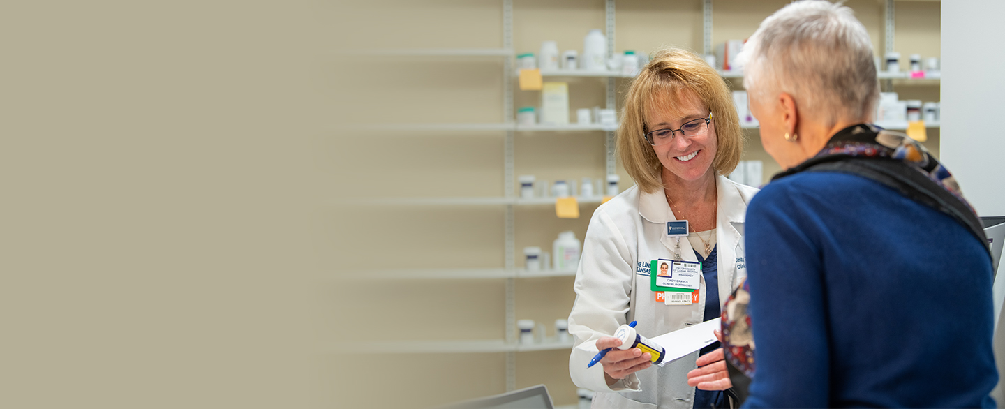 Patient picking up their prescription from pharmacist.